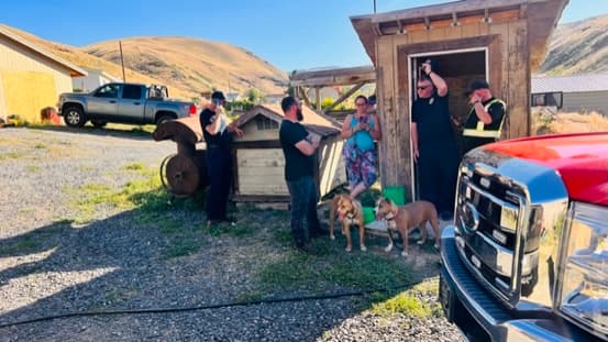 from left, in this photo: Jeremiah Johnson who is the Rivercom 911 OPERATIONS CENTER MANAGER, the actual tow operator, the female dispatcher they names as Jenna and now last minute have claimed is not and never has been a Rivercom employee... , unknown quiet man wearing wenatchee fire shirt, and possibly the other tow operator who had followed first tow operator as he drove my truck from the park to Jeremiahs home without my knowledge or consent, following him in the red B7T tow truck with a side by side ATV on bed. The two dogs are my passengers medical dogs and she never parts with them. They played on the element of causinf fear for my passengers safety by coddling her dogs and refusing to get her or say if she is ok, then laughing